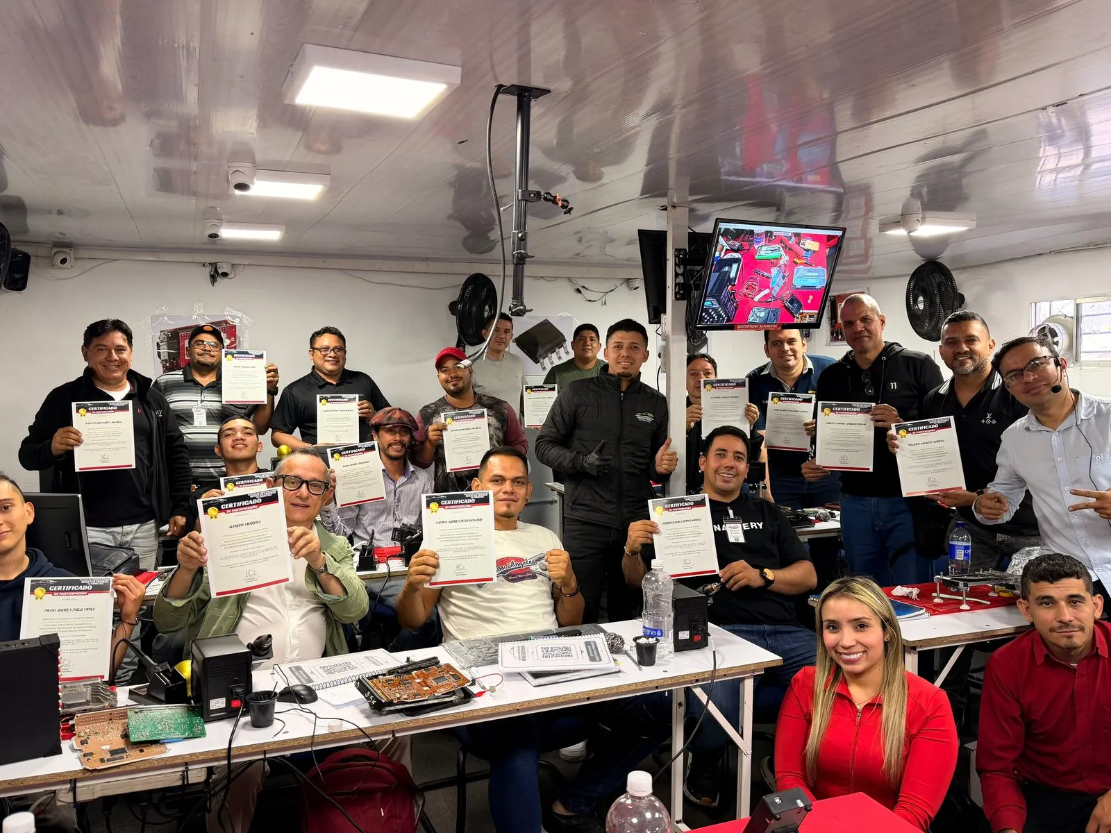 Egresados con sus certificados en el laboratorio